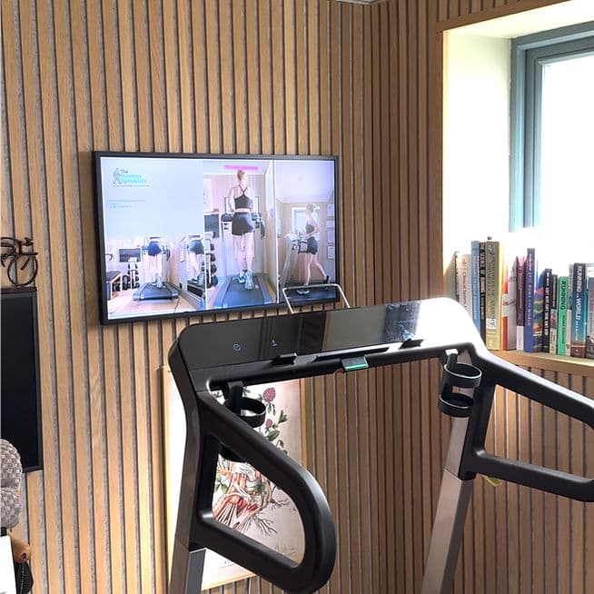 The clinic's treadmill with a multi-angle video screen showing gait analysis footage