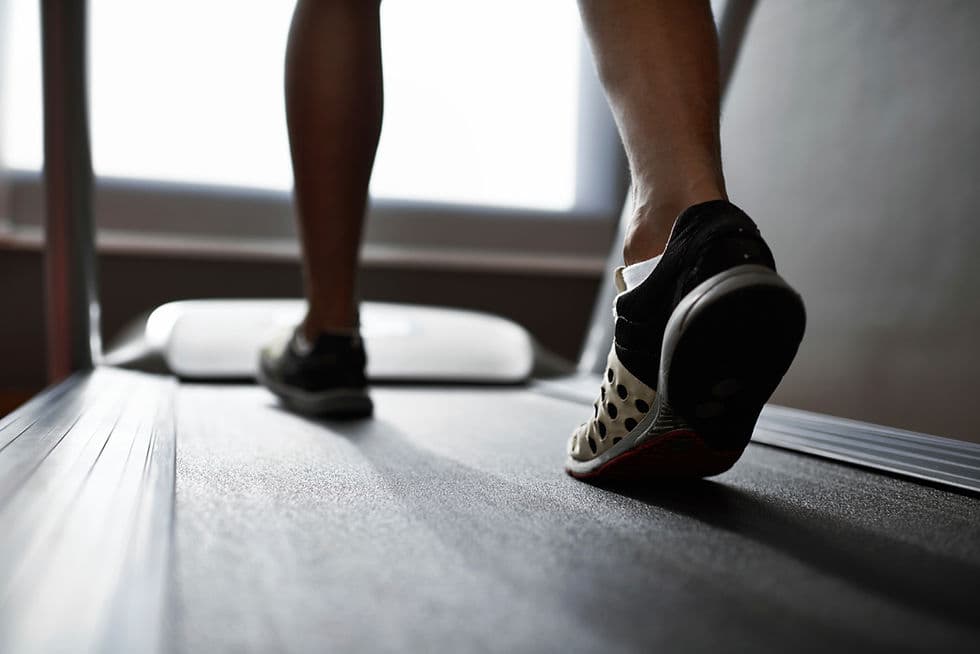 Close-up of a runner's feet on a treadmill during a gait analysis session